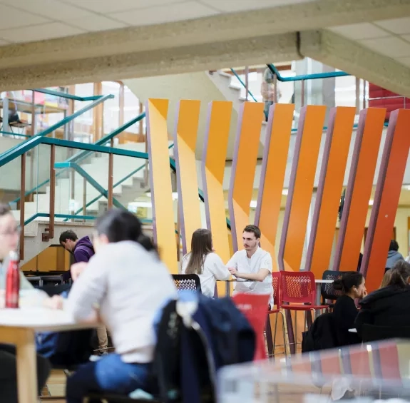 C'est la rentrée à la HEdS-Genève, les étudiants sont attablés dans le hall et discutent